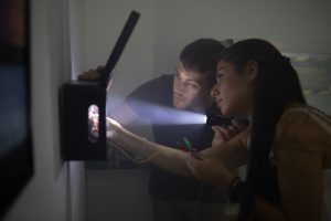 Eine Gruppe untersucht den Alarmkasten im Escape Room "Projekt Vakium" der Adventurebox Münster