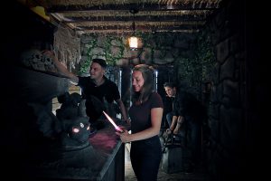 Gruppe erkundet den mysteriösen Altar in der stimmungsvoll eingerichteten Grabkammer des Escape Rooms Jäger des verlorenen Grabes – Adventurebox Münster