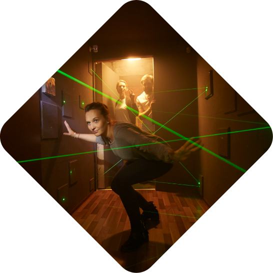 Eine Person steigt durch einen mit Lasern gesicherten Geheimgang im Escape Room Impossible der Adventurebox Münster