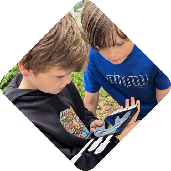 Zwei Kinder lösen während einer Geburtstagsfeier ein Rätsel des Outdoor Exitgames Operation schwarze Viper der Adventurebox Escape Room Münster